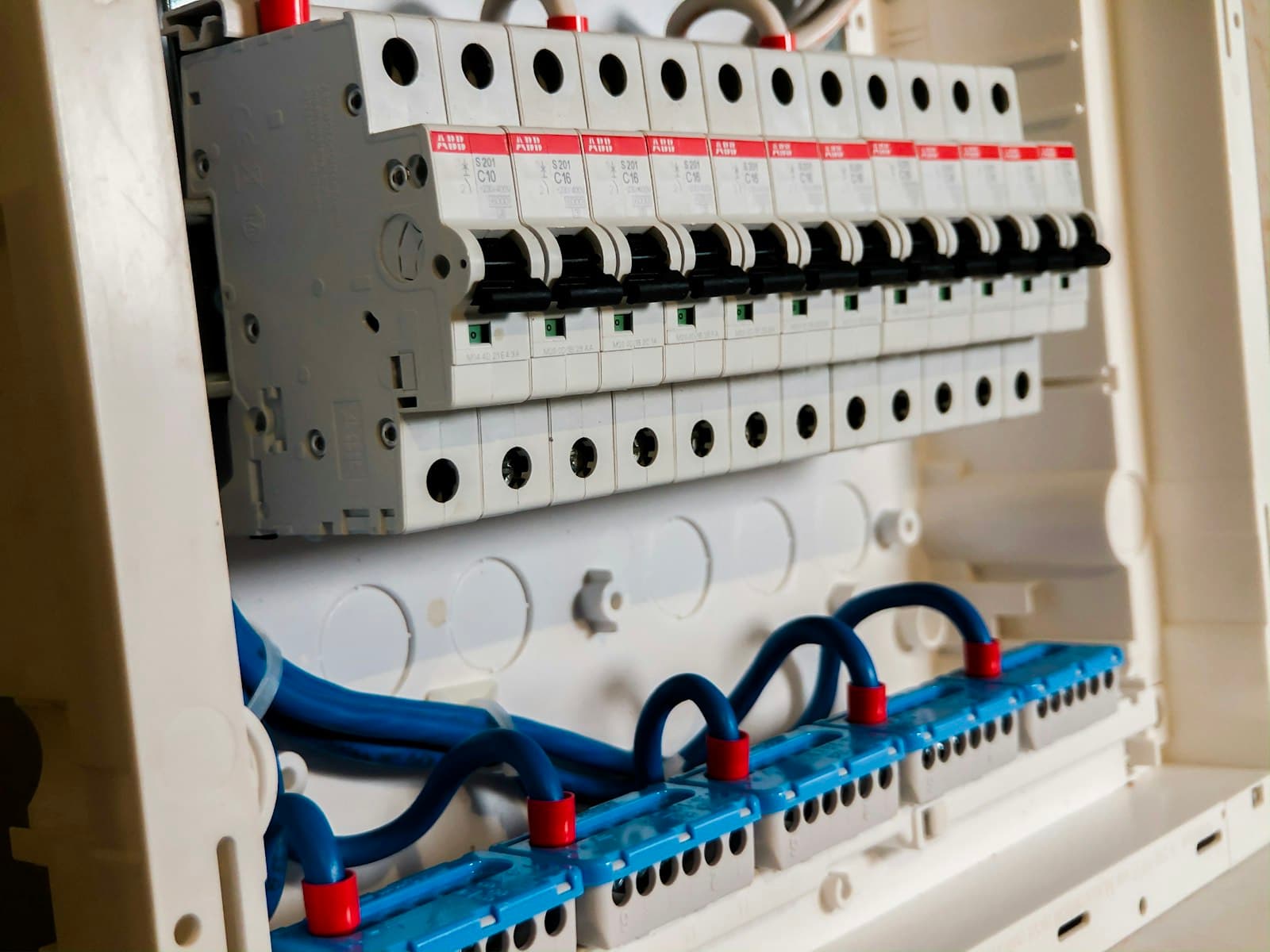 Tableau électrique modulaire blanc avec rangées de disjoncteurs — installation résidentielle conforme NF C 15-100